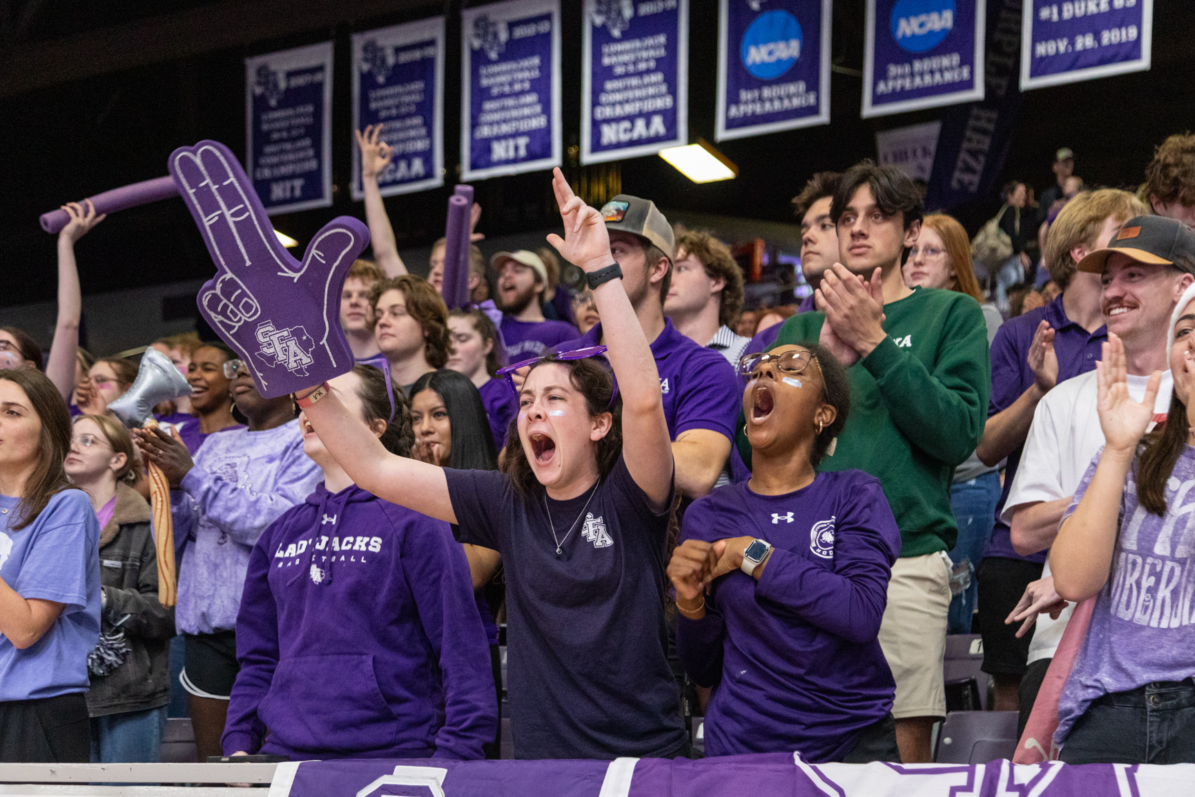 Students cheer during the first half of a basketball game against McNeese State University, inside Johnson Coliseum. Series produced for Stephen F. Austin State University marketing material, 2025.