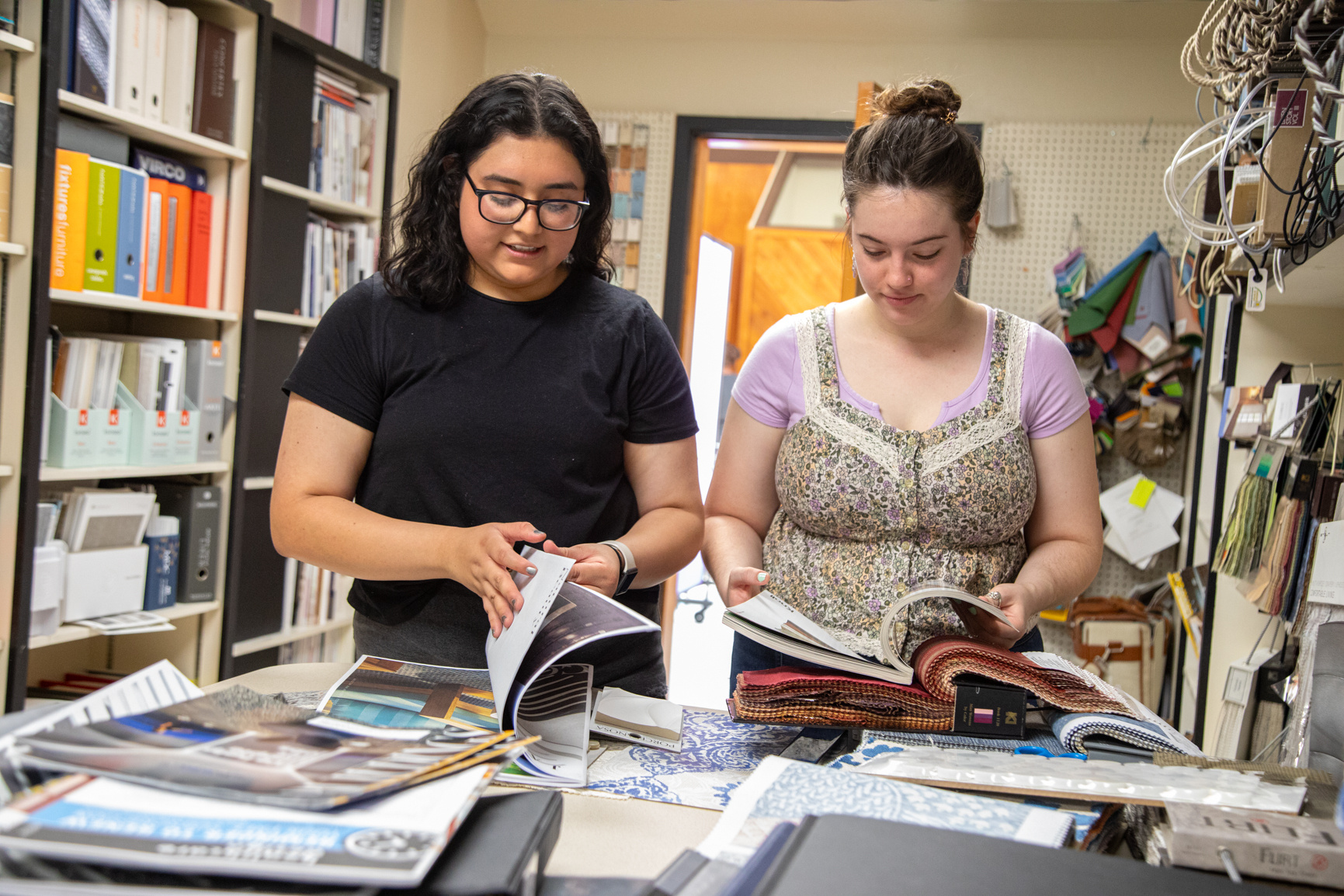 Interior design students look through material in the Human Sciences Building South during a media production day. Series produced for Stephen F. Austin State University marketing material, 2025.