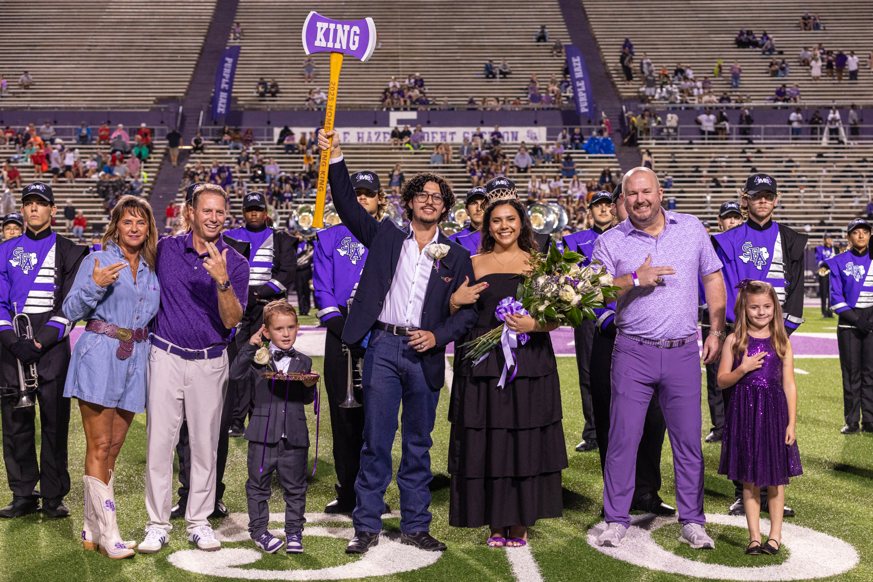 A student raises an axe after being crowned homecoming king during the homecoming football game against Nicholls State University.
