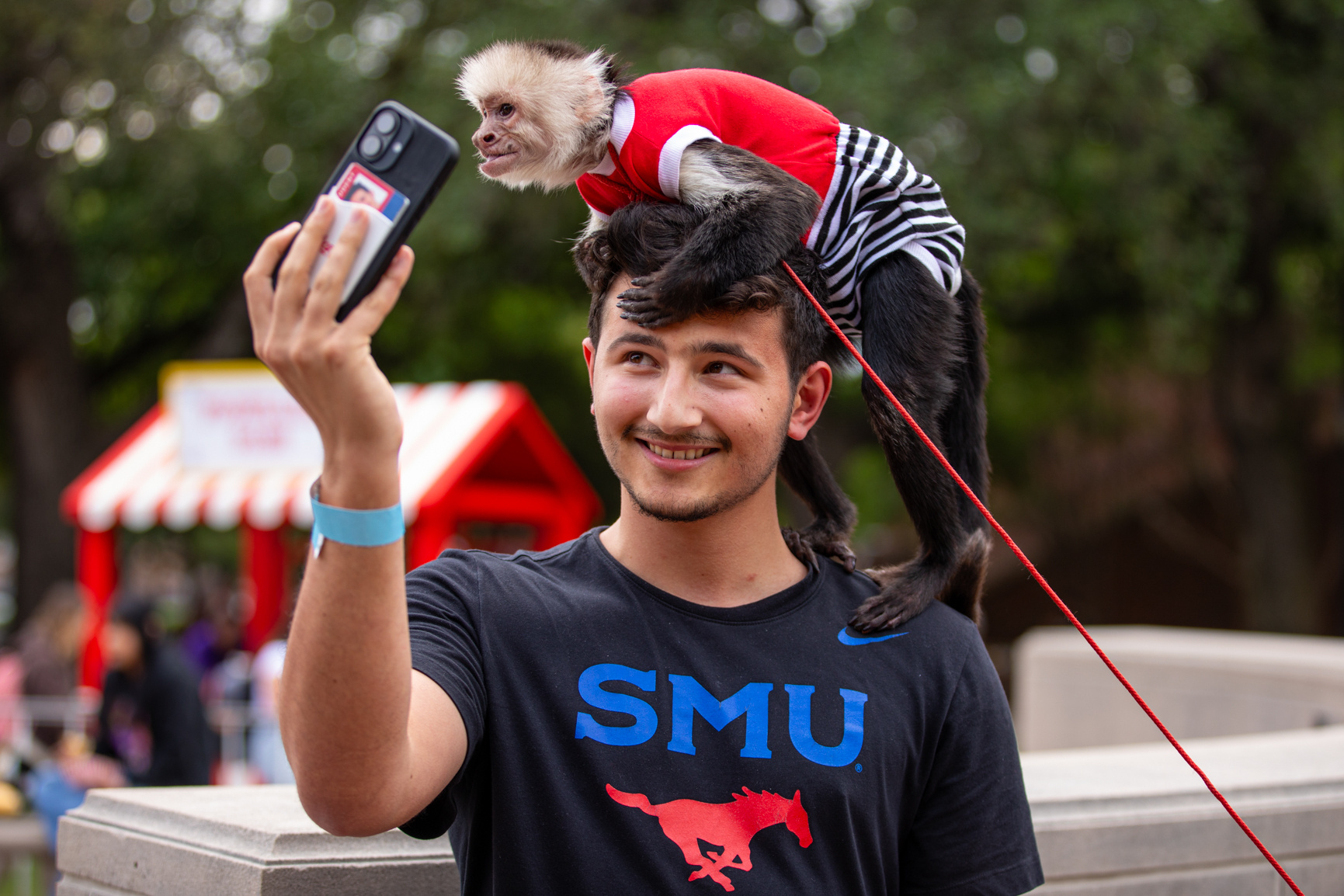 A student smiles as a monkey sits on his head during the Residents Commons Cup Competition, an annual event that brings residence hall communities together in friendly competition. Series produced for Southern Methodist University marketing material, 2025.